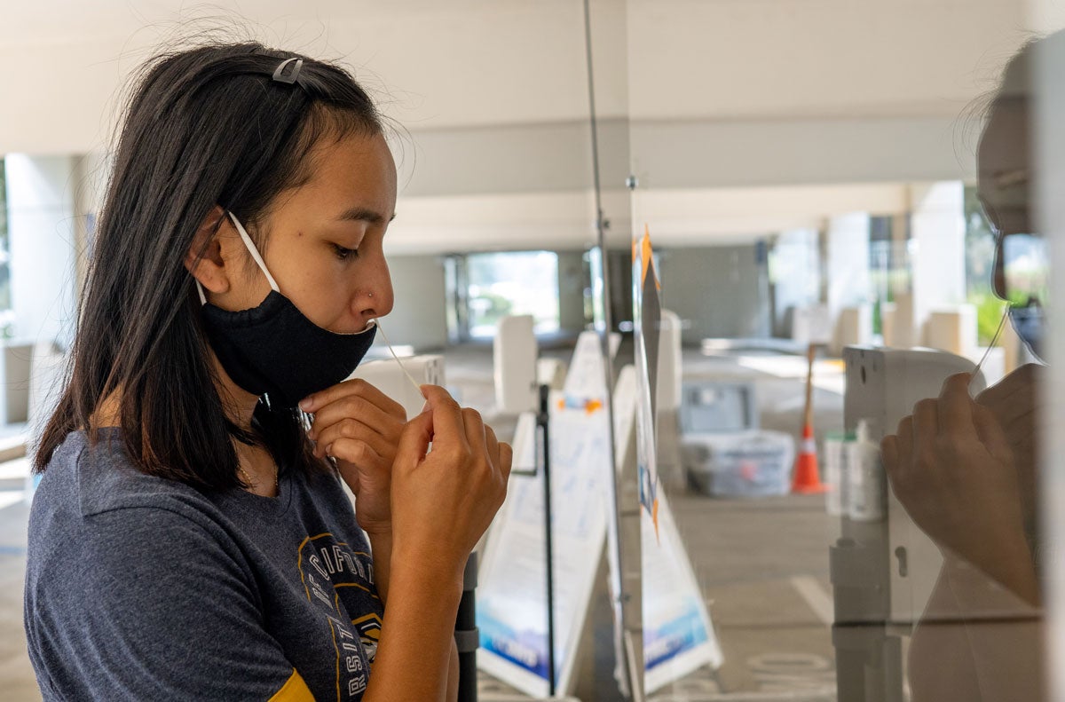 Katherine Yanogacio self-administers nasal swab test.