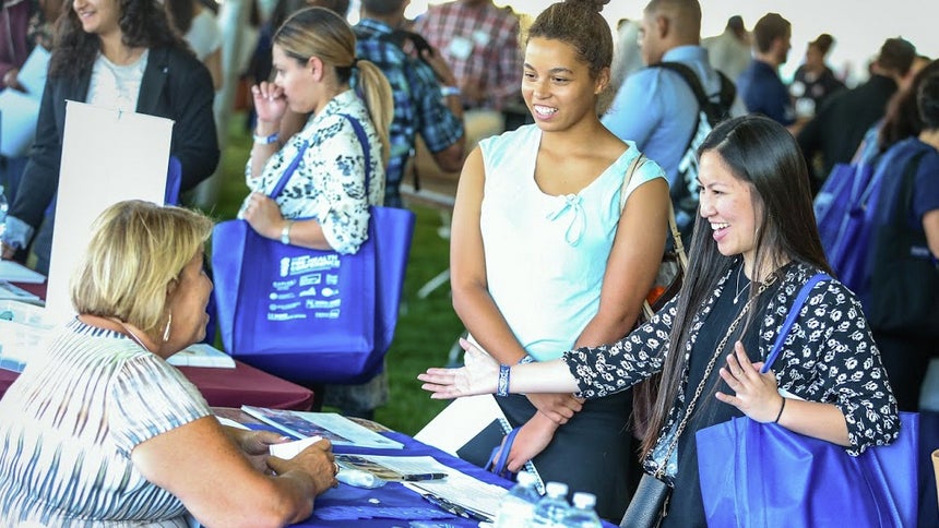 students visiting a conference booth
