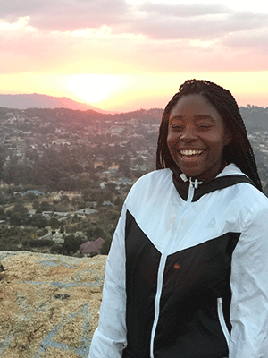 Student in front of sunset.