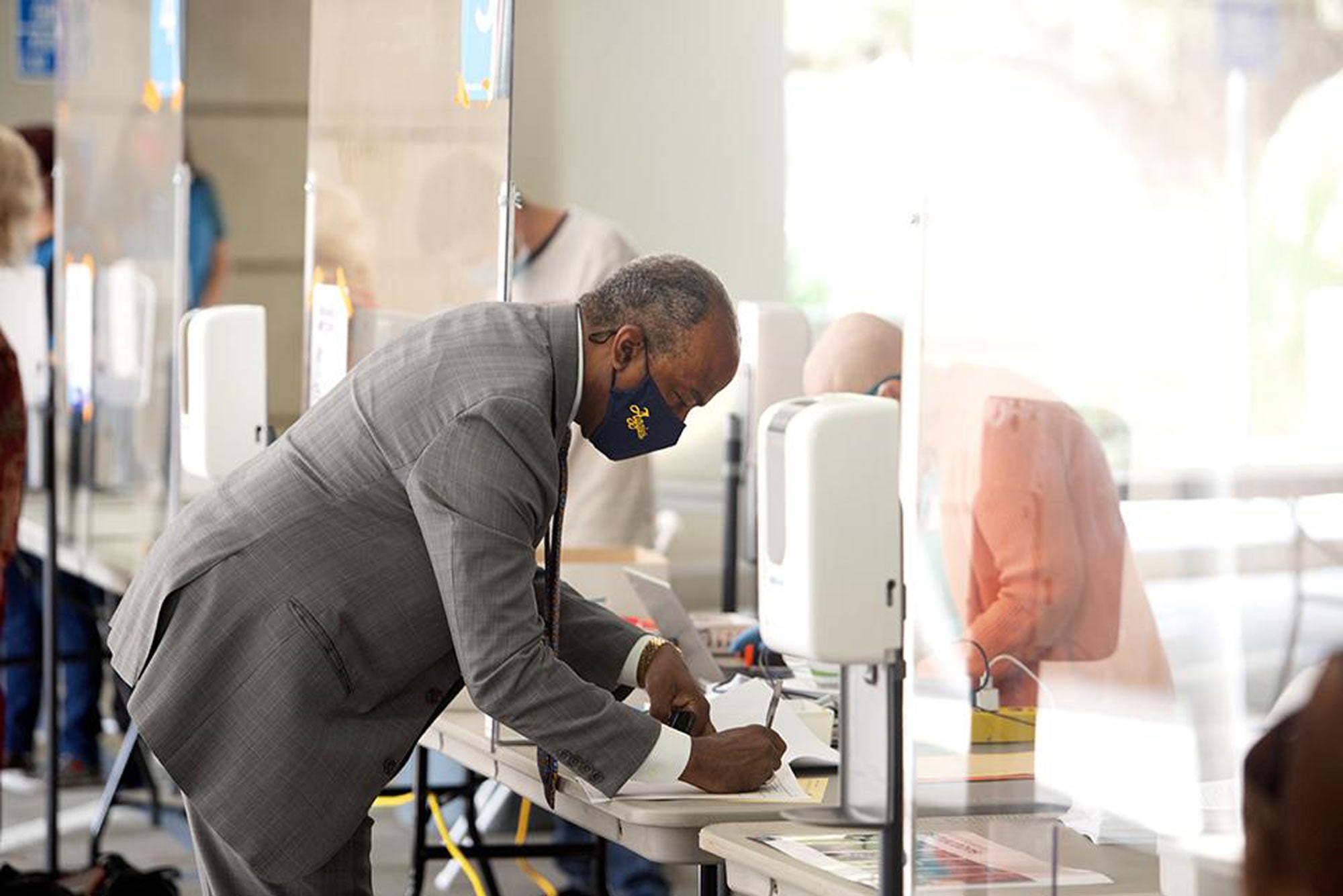 Man in mask signs in for saliva test