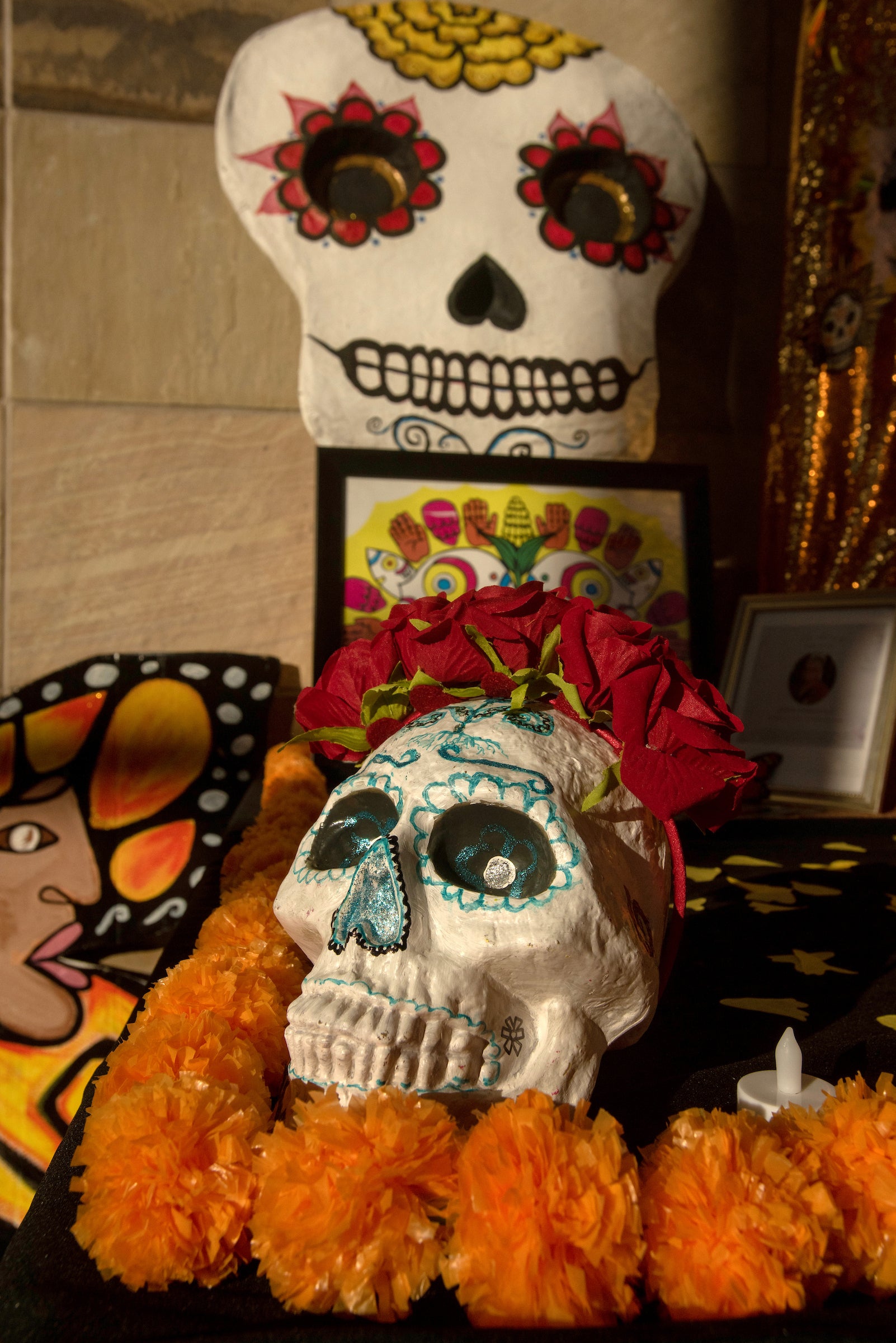 Skeleton figure mask, orange decorations at dia de los muertos display at Mondavi Center