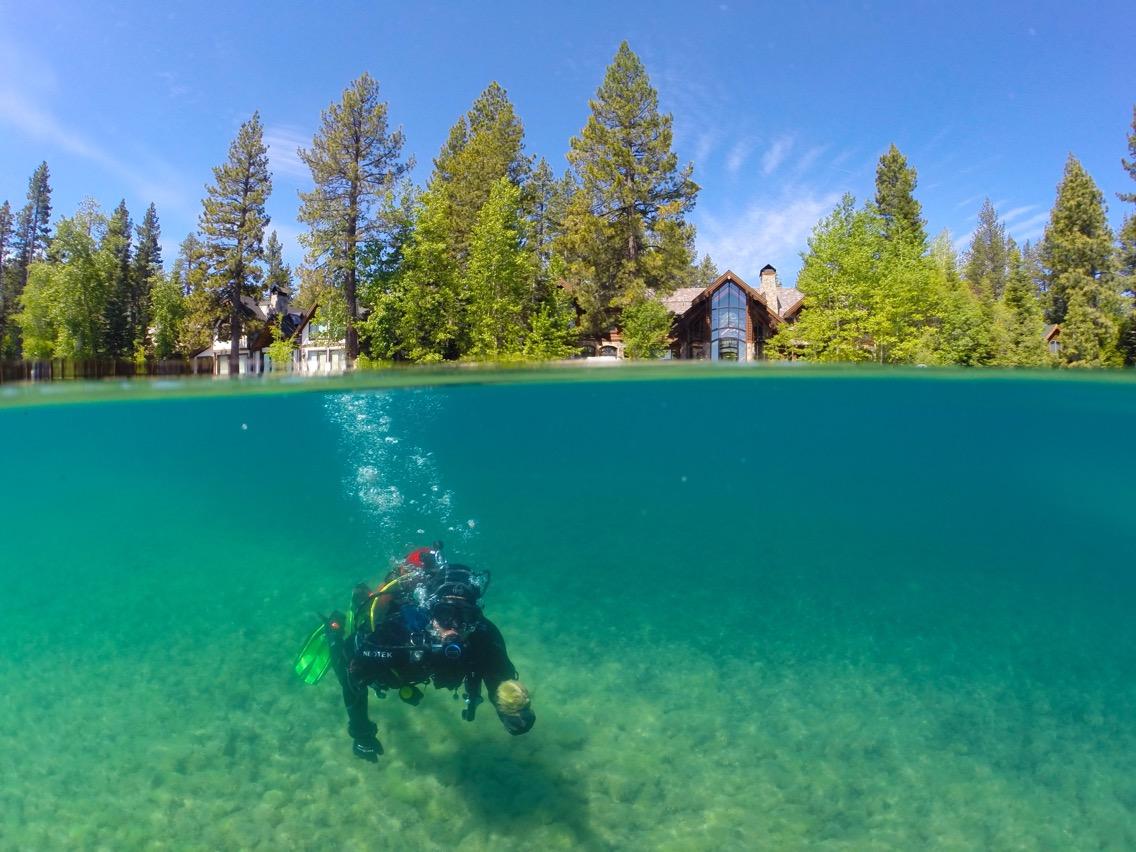 Diver Brandon Berry under greenish blue water of Lake Tahoe while sampling for algae