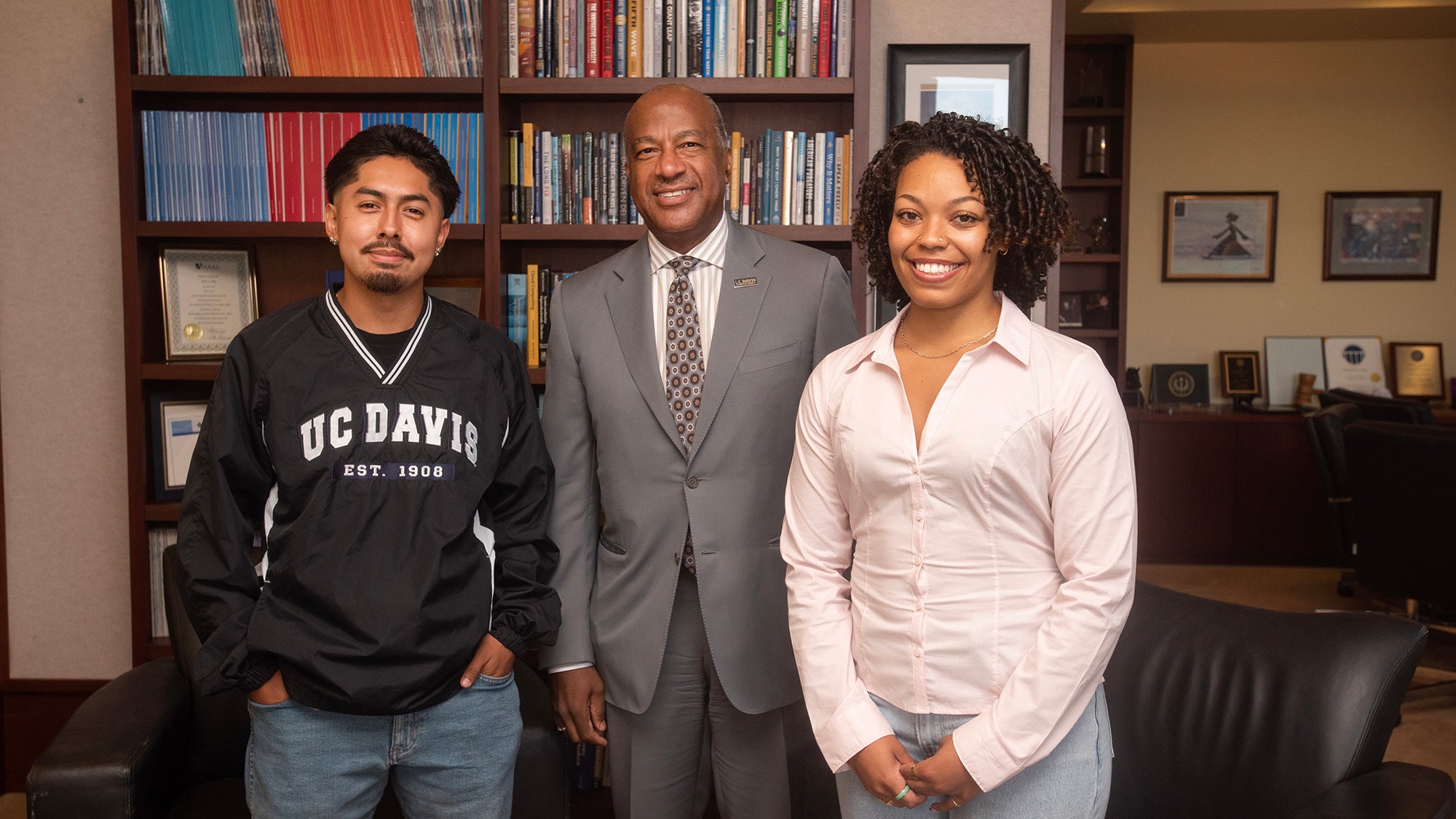 Three people stand in an office