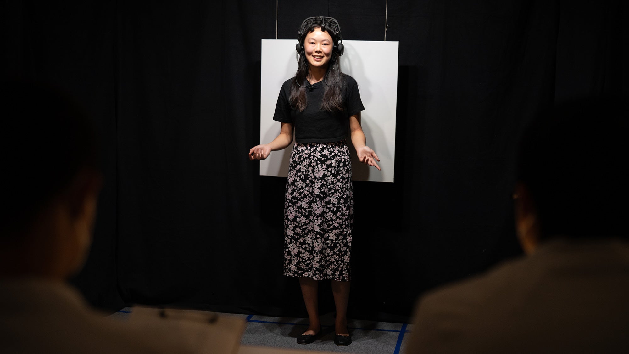Student wears EEG equipment while public speaking in a dark room