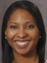 Smiling woman headshot with straight dark hair, pearl stud earrings, gray background