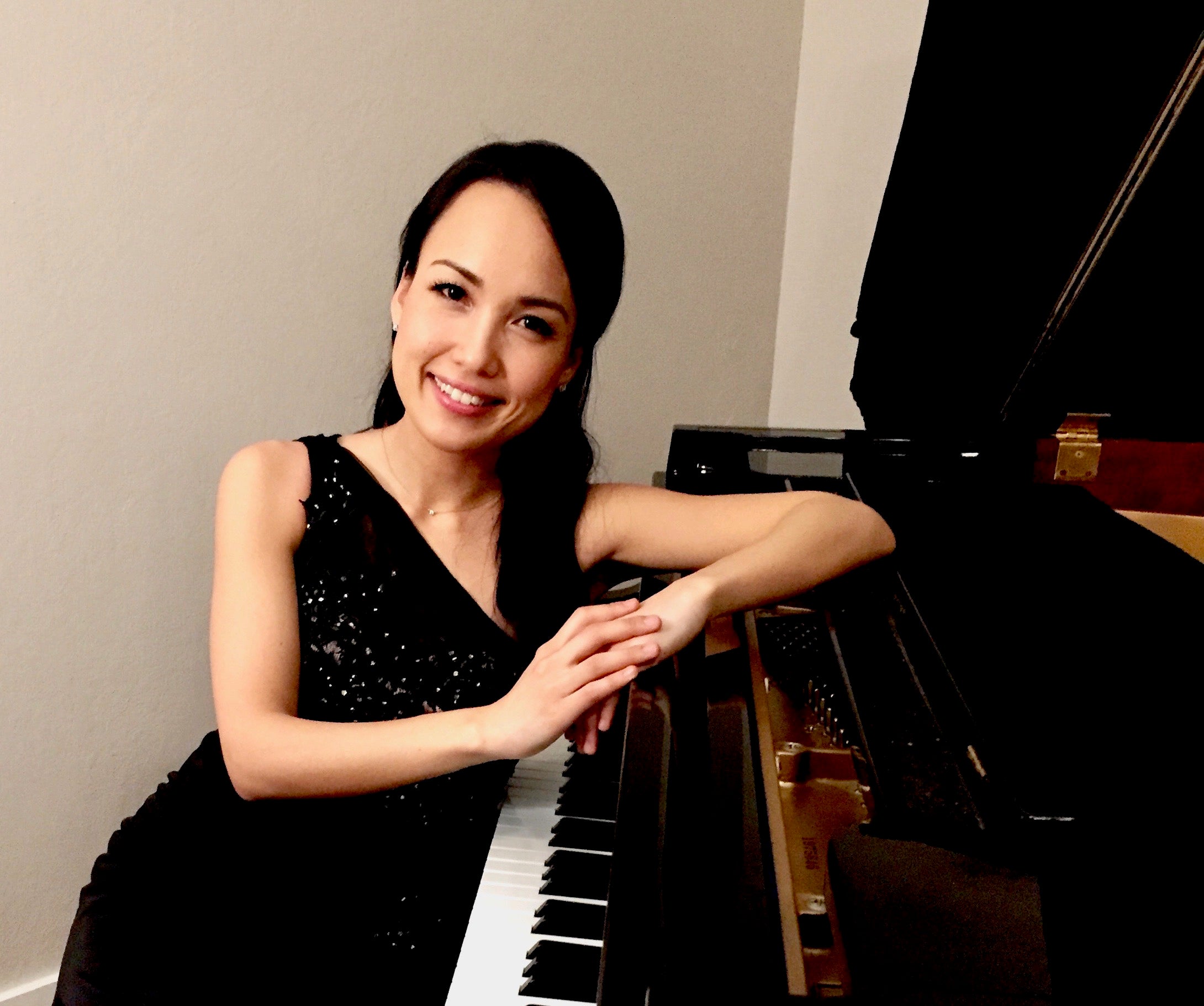 Woman dressed in black sitting at piano