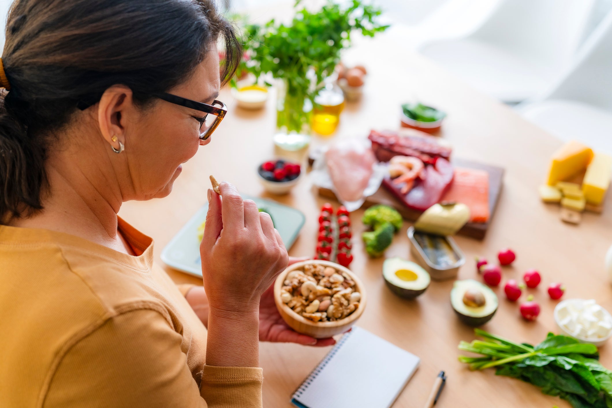woman eating nuts and other healthy food