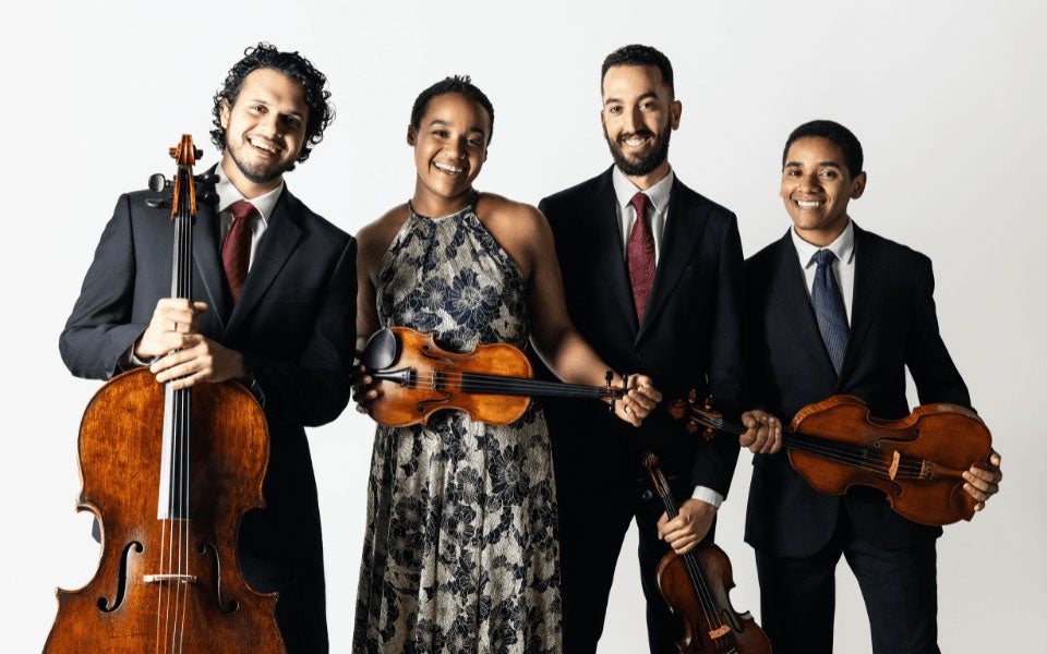 Ensemble group posing with string instruments