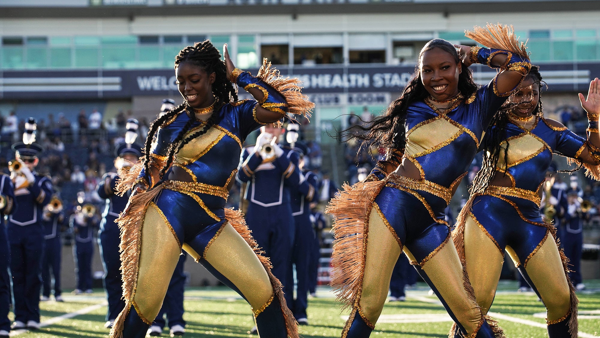 Members of the Majorettes dance group perform on the field during a football game