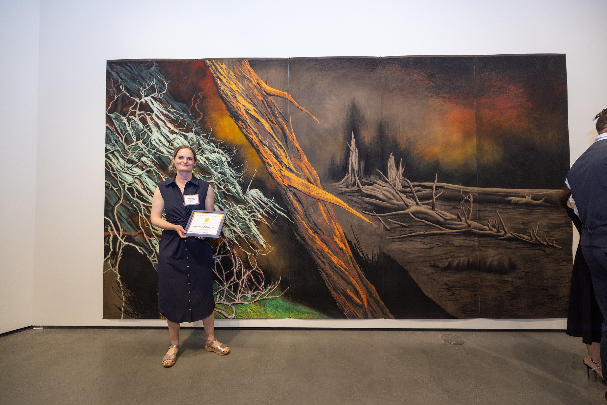 Student standing in front of artwork