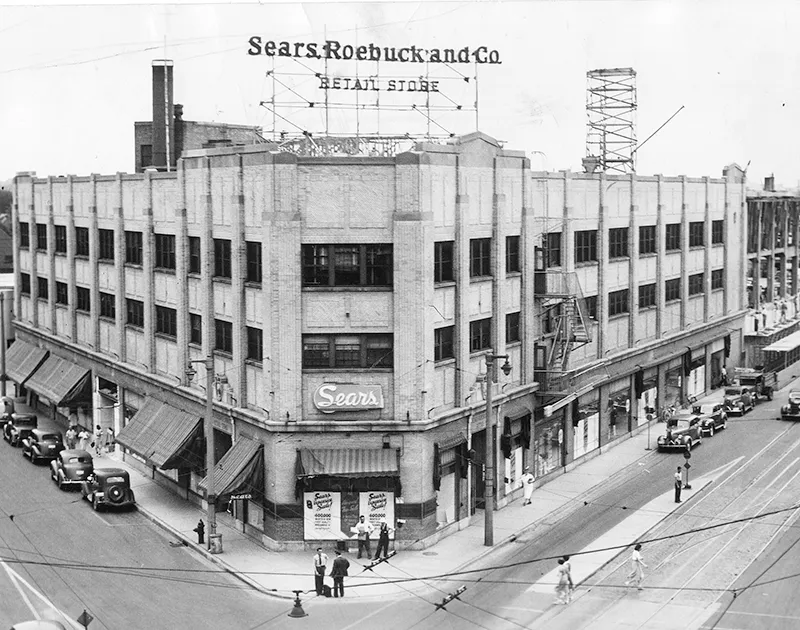 Black and white photo of the exterior corner of a large Sears department store, circa 1930s