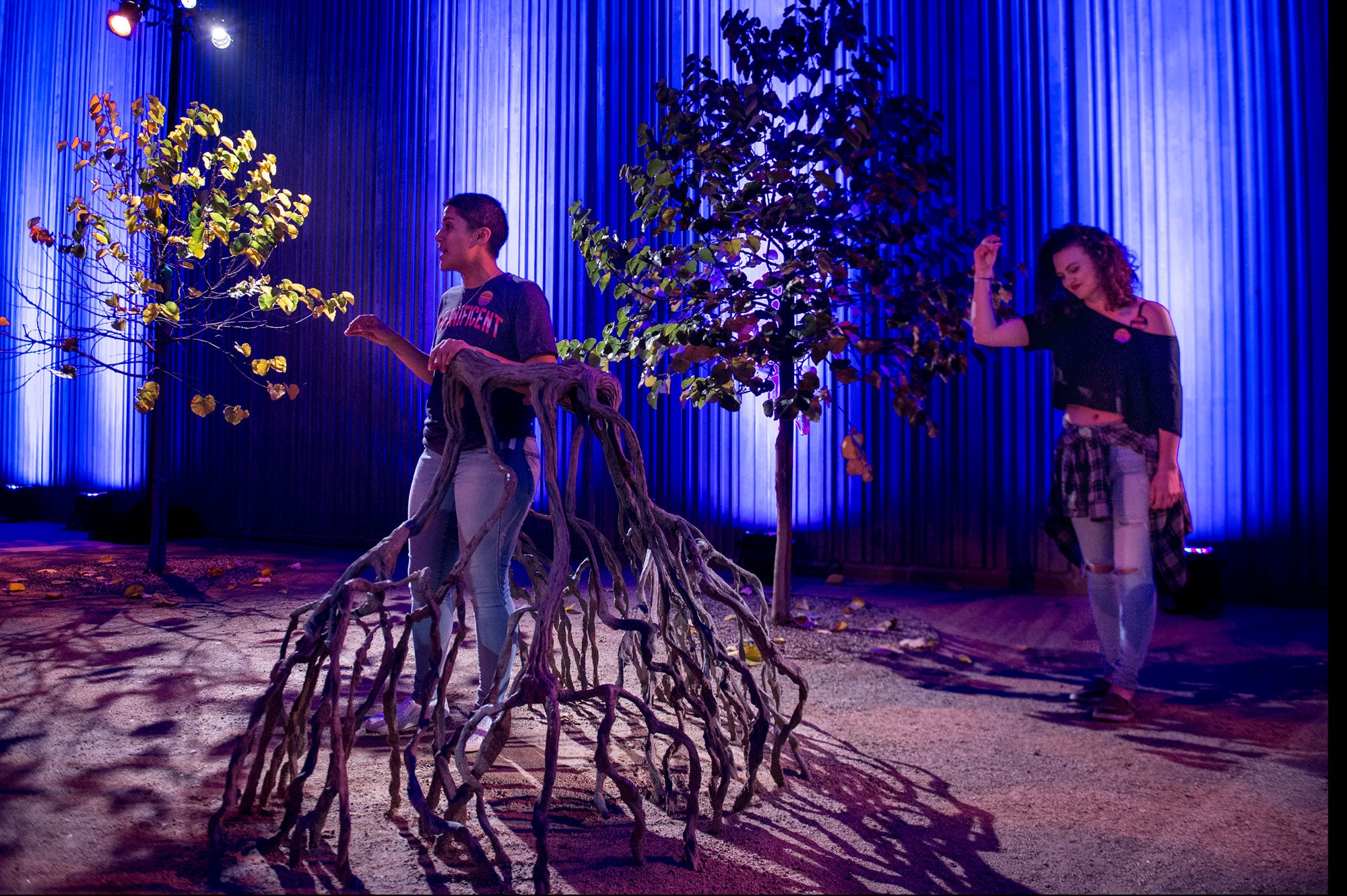 Students perform around sculptures of Sandra Shannonhouse in lighted even shrouded in blue