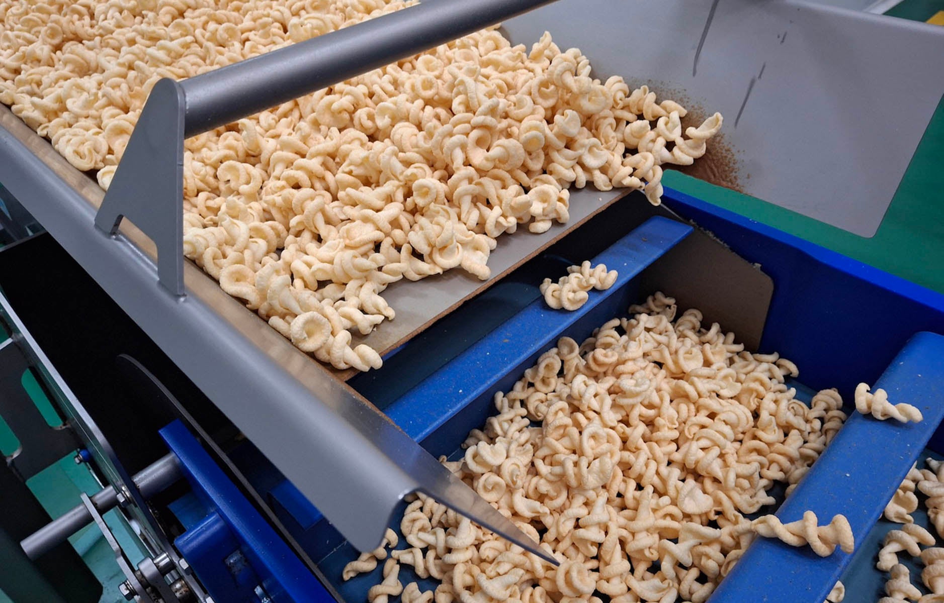Tornado-shaped snack chips on a conveyor belt in a snack factory. Depending on additives, many snack chips are considered ultra-processed. (Getty)