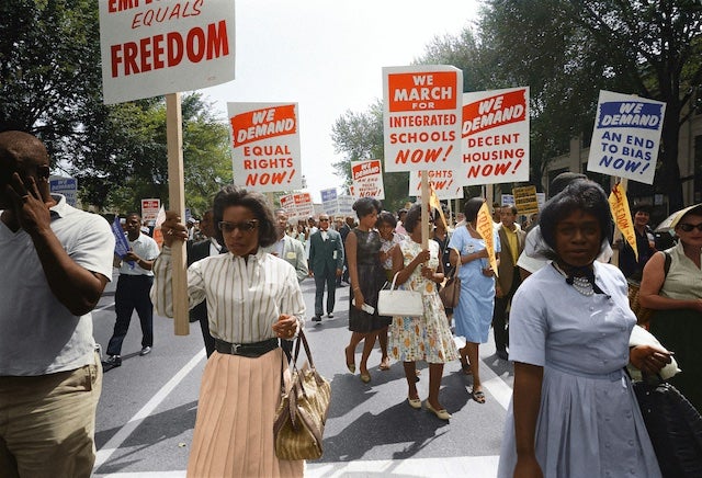 Photo of marchers with signs demanding integrated schools and equal rights.
