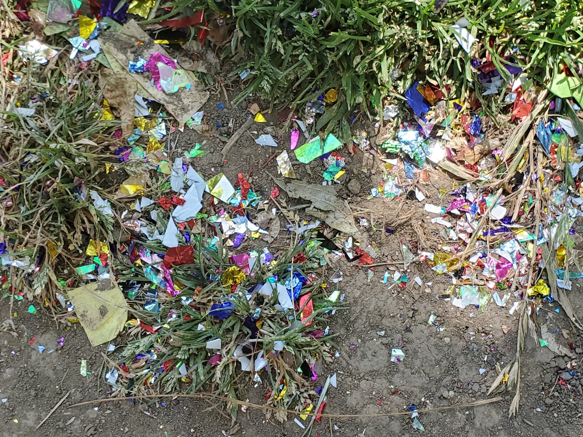 Metallic confetti covers the ground in front of the UC Davis sign