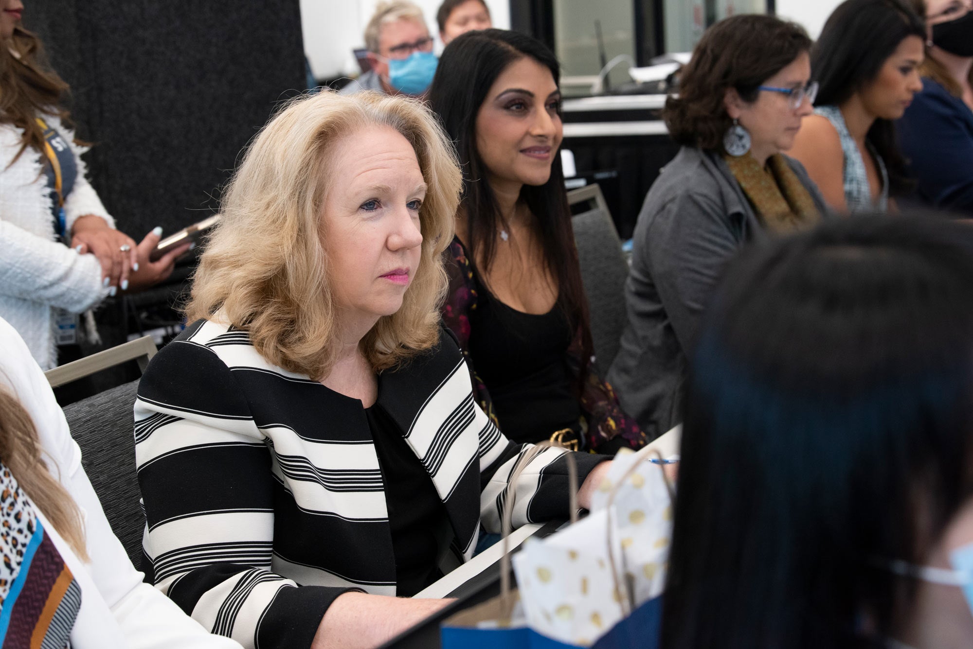 Woman listens to presentation, as a judge