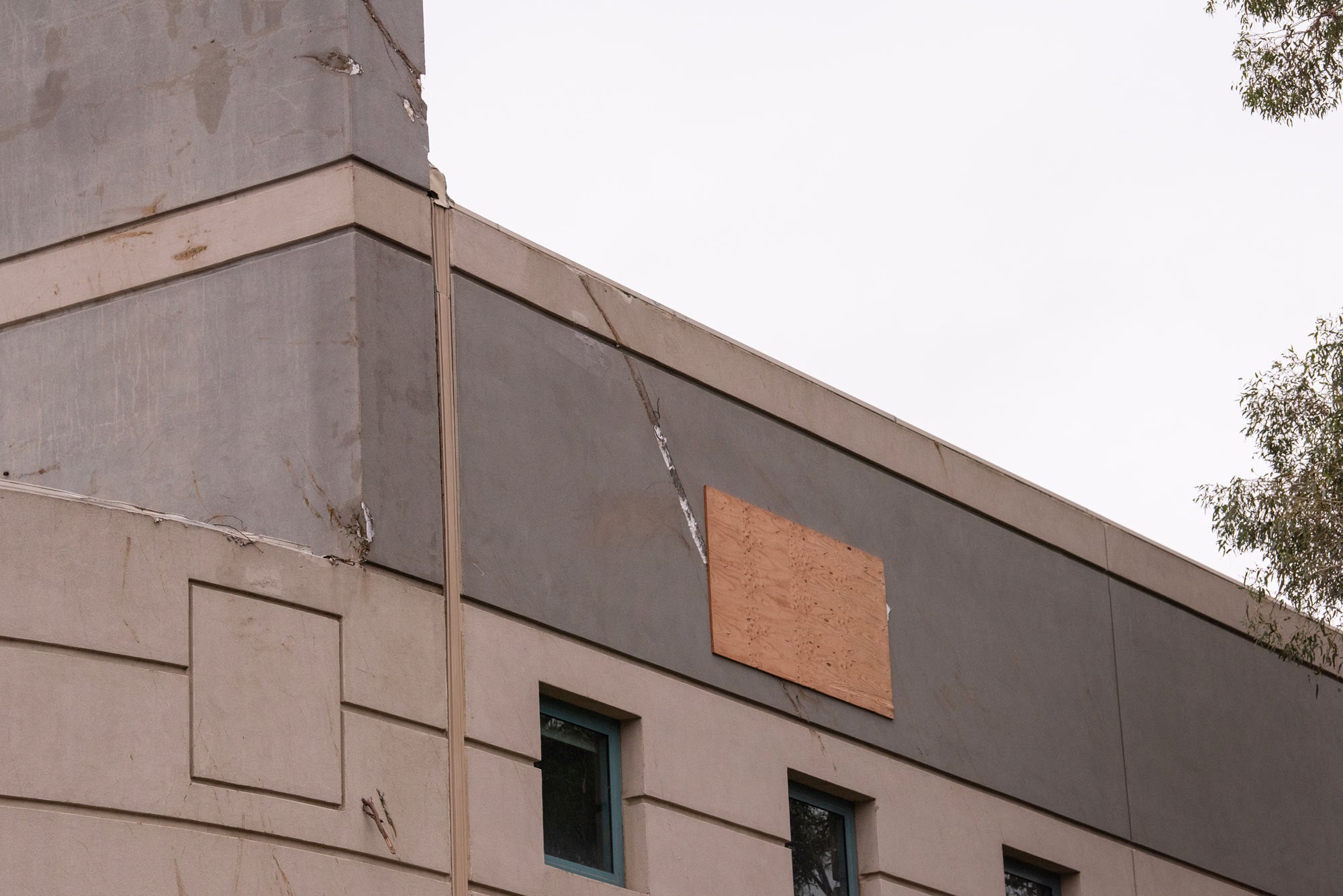 Sheet of plywood covers hole in building wall