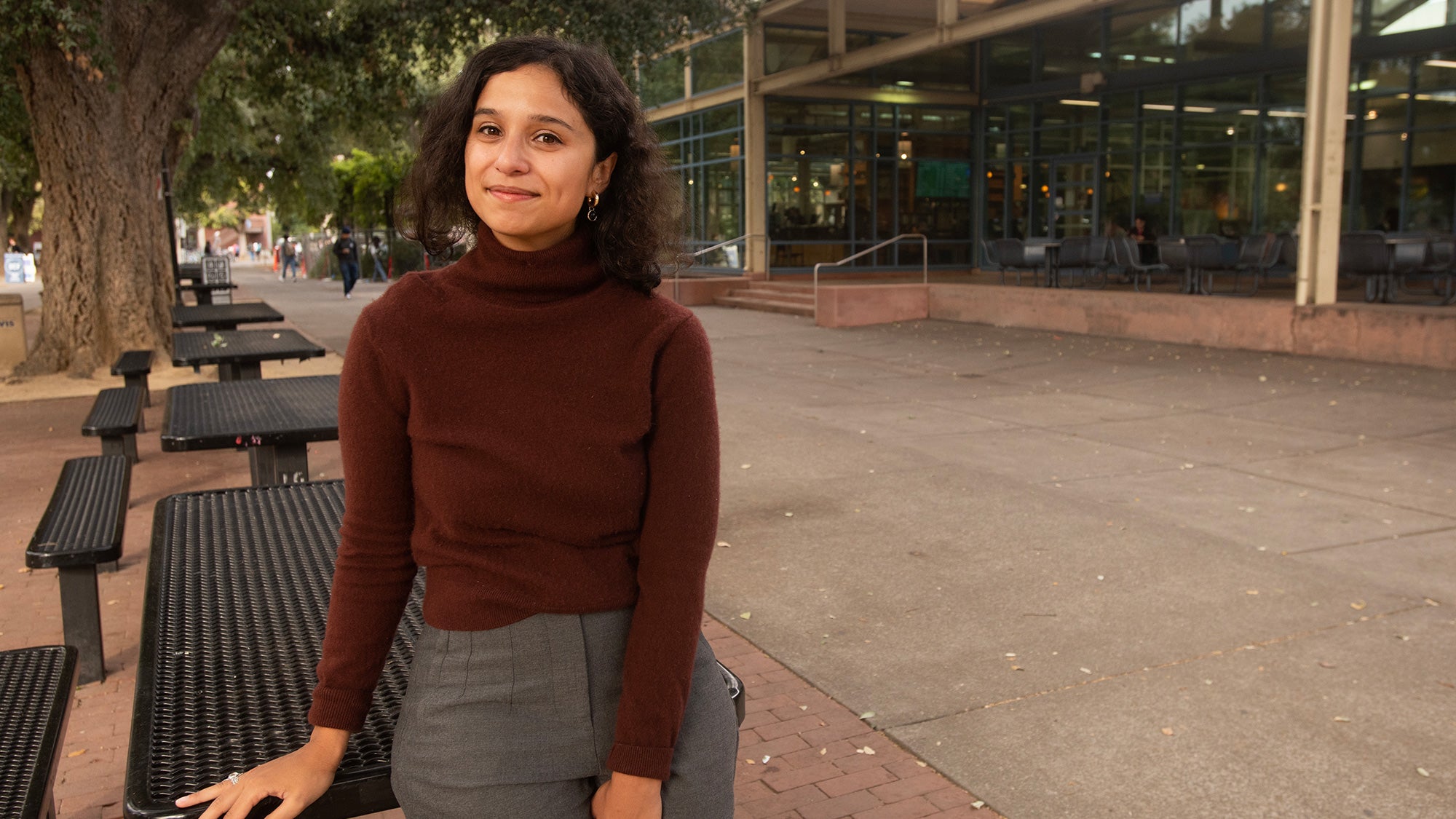 Woman sits at a table near the Memorial Union at UC Davis