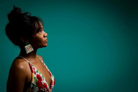 Dark-complected woman on left with teal background