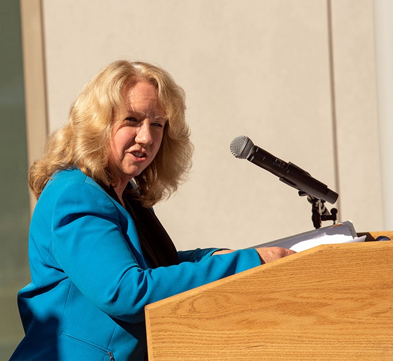 Mary Croughan speaks at lectern.