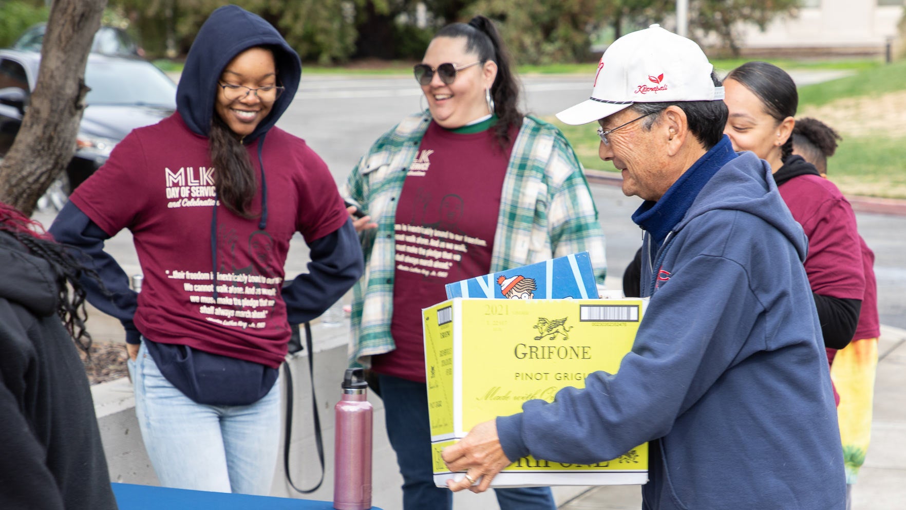 Man carries box of school supplies to law school students at the collection table