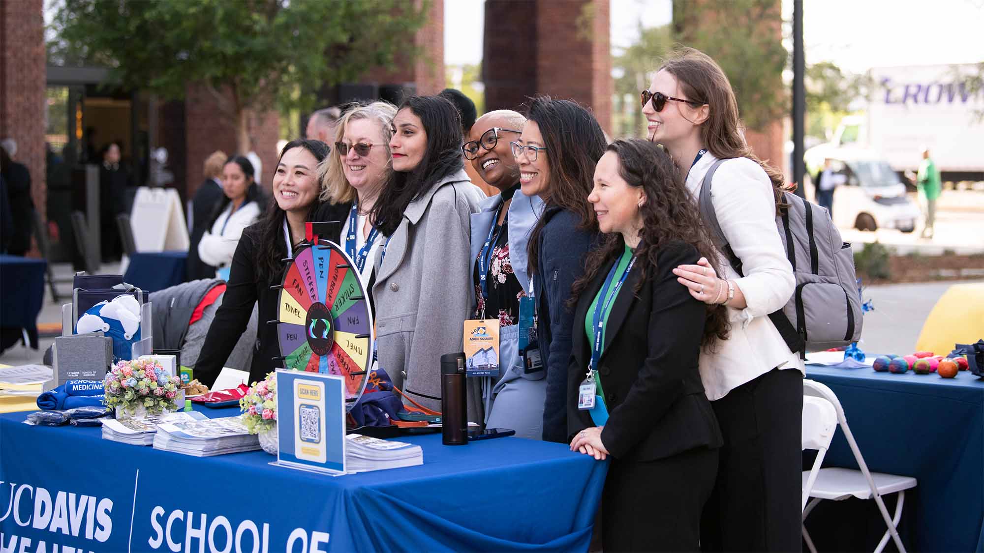 People at exhibition table pose for group photo