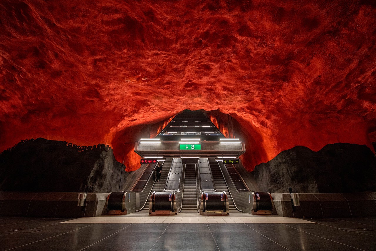 Escalator passes through red ceiling.