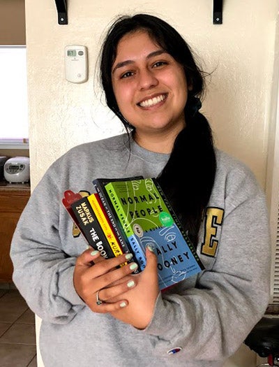 Tana Madrigal holds books.