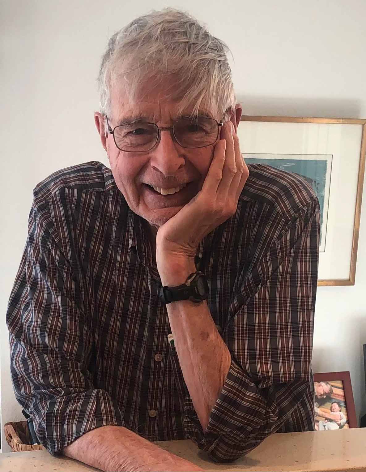 Theodore L. Hullar leans on table