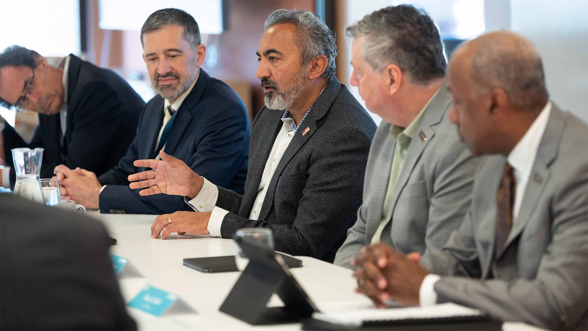 Ami Bera speaks at table as other people look on