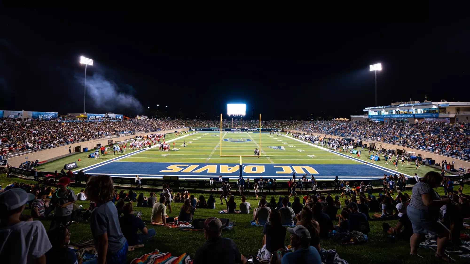 Photo of UC Davis Health Stadium during evening football game shows large crowd