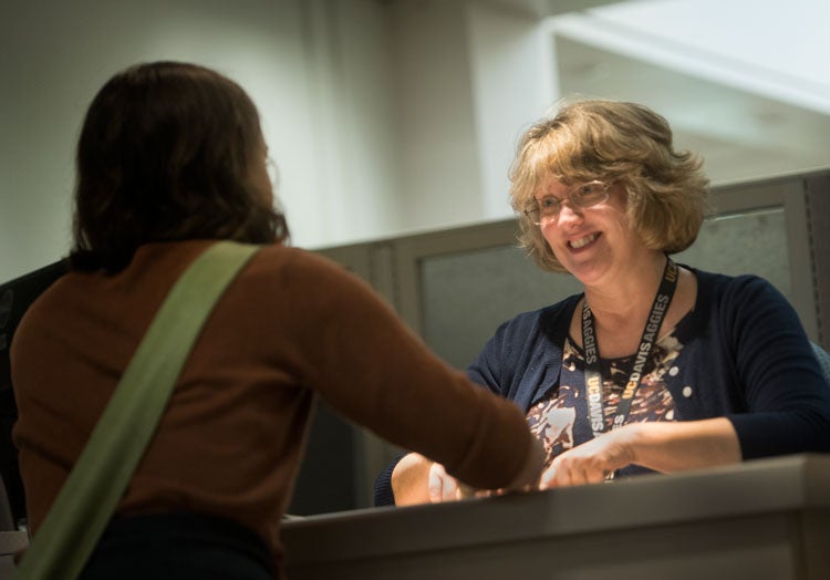 Cynthia Crestmore works behind the Mrak Hall reception desk.