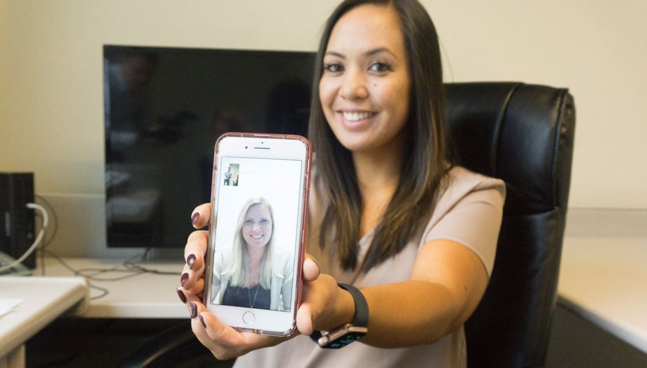 Kristine Seraspi holds up smartphone.