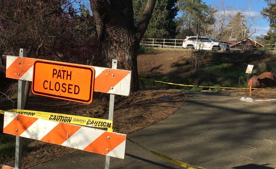 Sign says "Path Closed" on arboretum patrh, near La Rue Road bridge in background.
