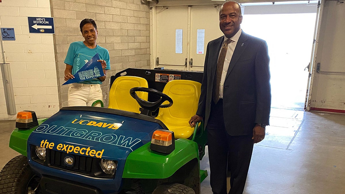 Chancellor Gary S. May and LeShelle May with a John Deere Gator.