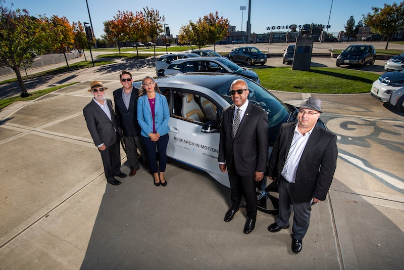 Transportation Researchers in front of an electric vehicle at UC Davis
