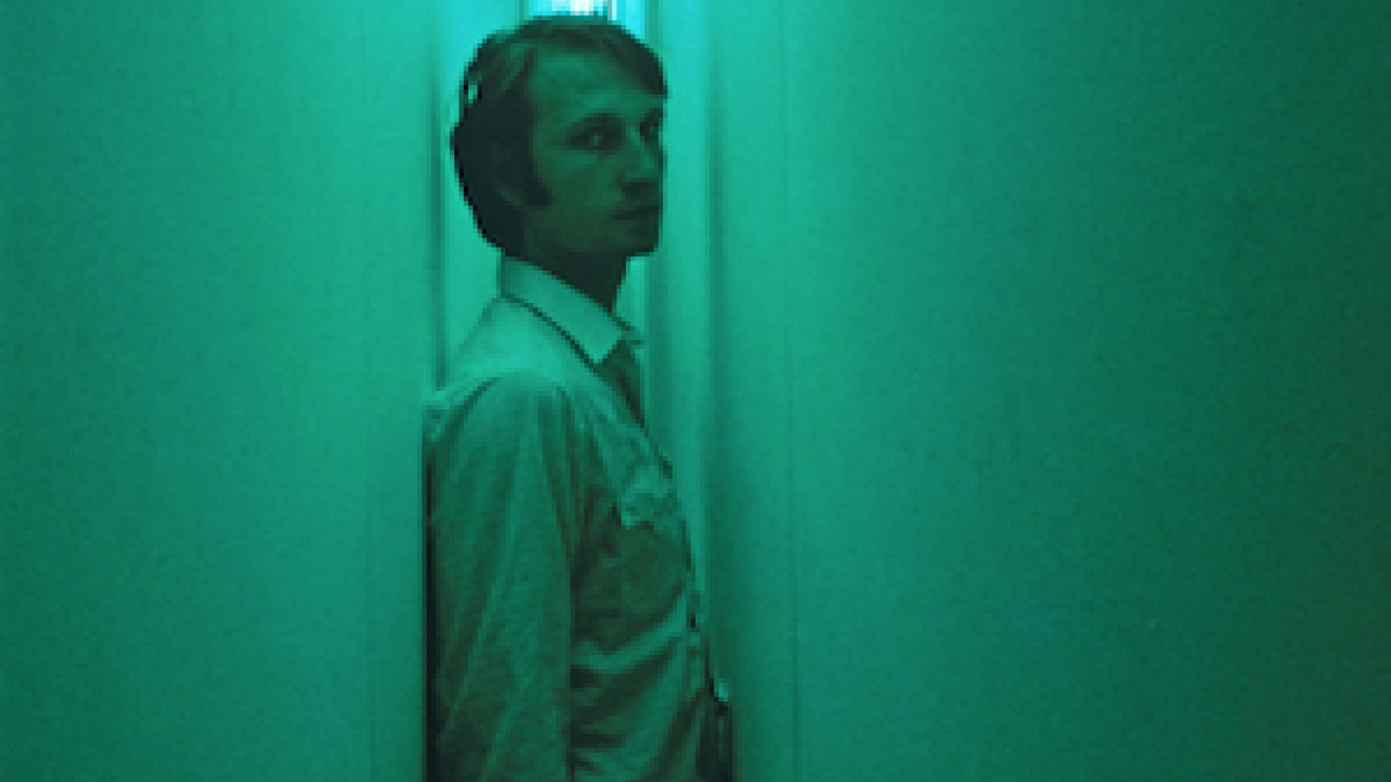 A man standing in Nauman's Blue and Yellor corridor.