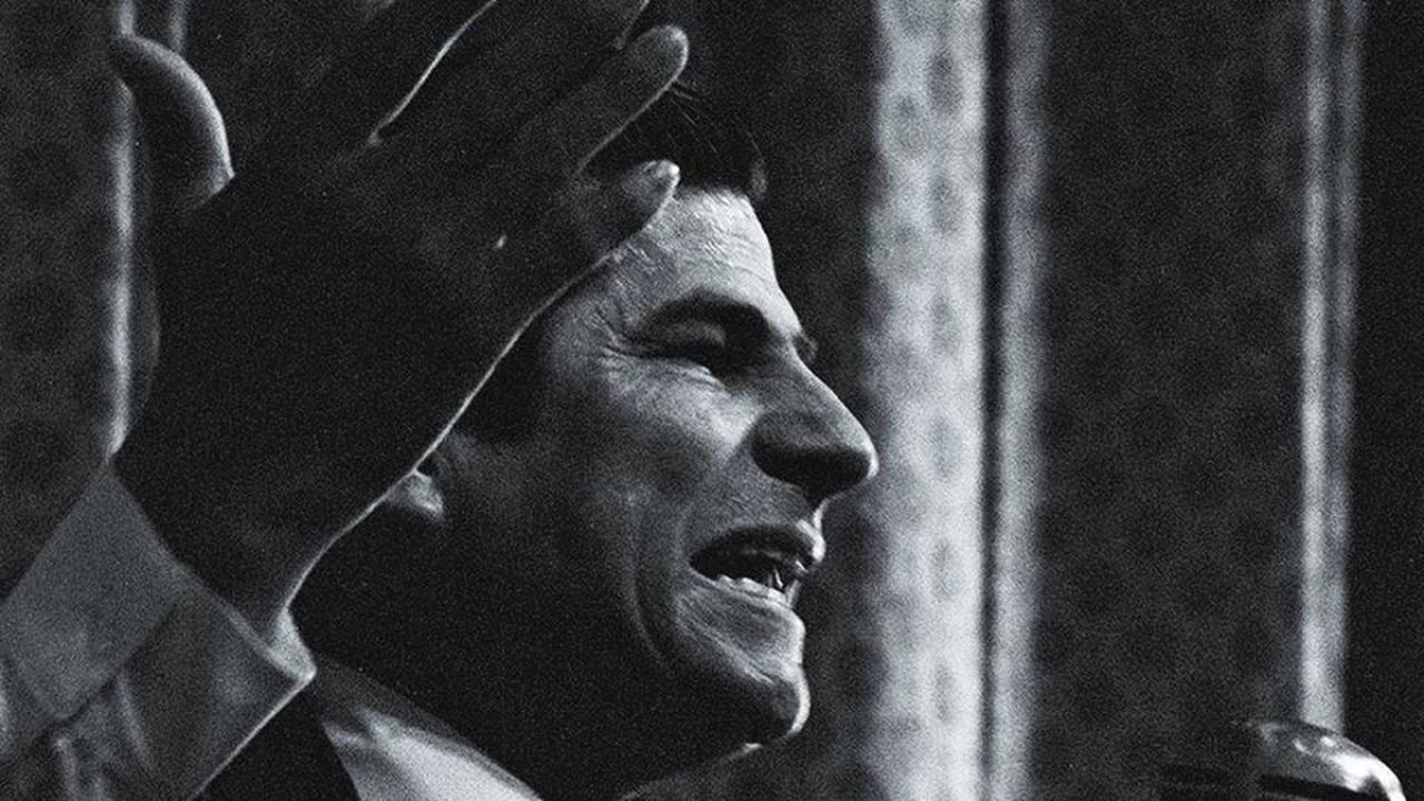 Book cover, cropped, showing black-and-white image of Reies Lopez Tijerina  at microphone, hand raised.