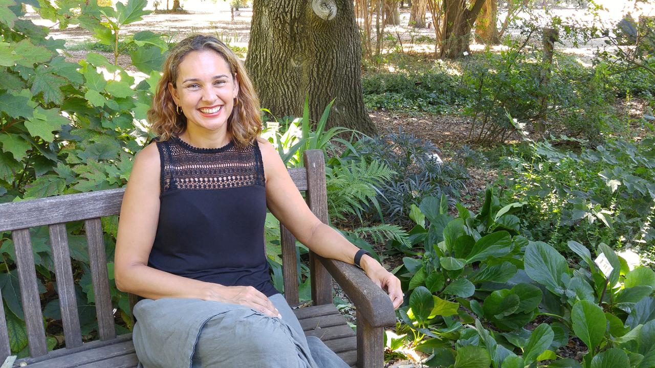 Plant scientist Siobhan Brady sitting on a bench with plants.