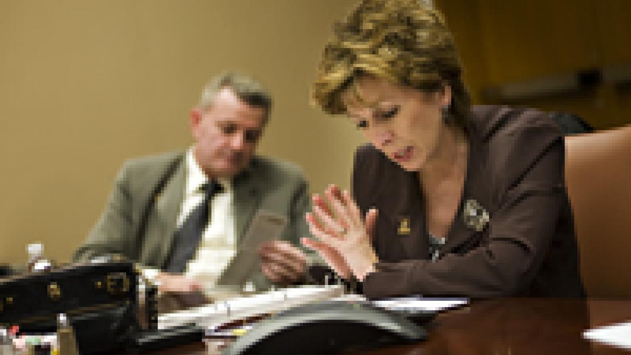 Linda Katehi speaks with reporters by telephone on May 7. Her husband, Spyros Tseregounis, is seated next to her.