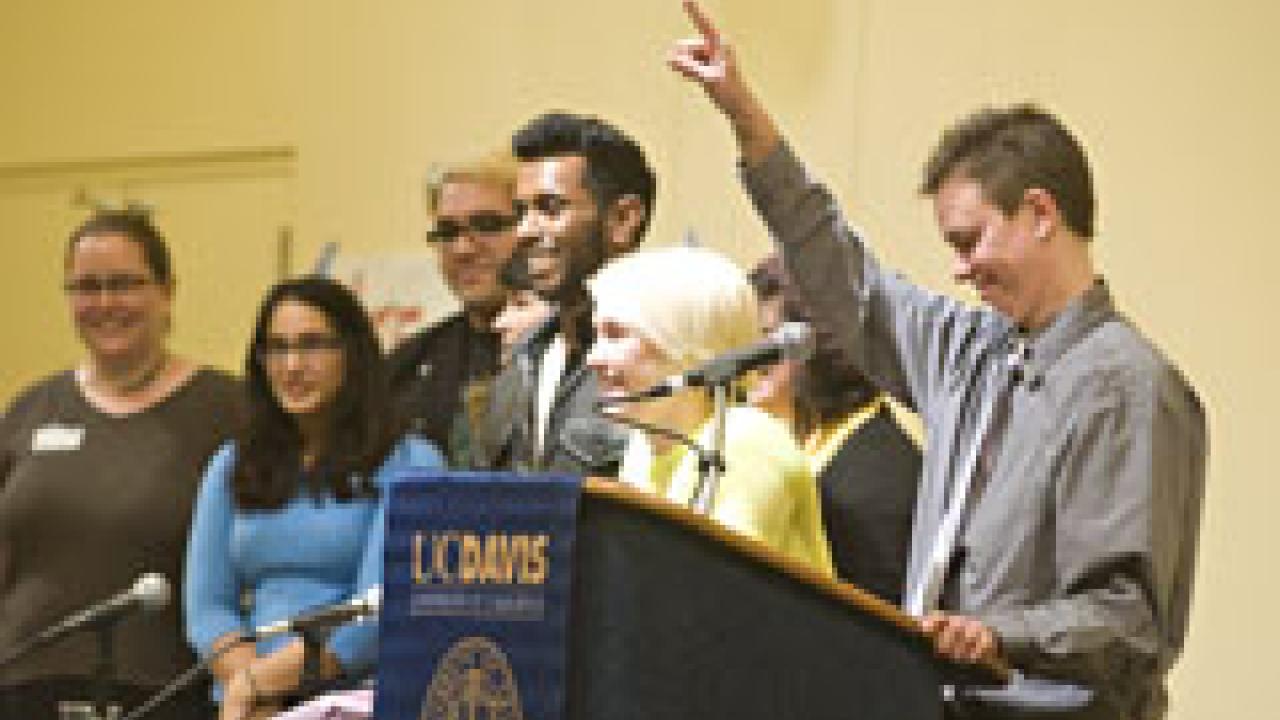 Sheri Atkinson, right, standing beside the staff of the Lesbian, Gay, Bisexual and Transgender Resource Center, tells the town hall audience in the ARC Ballroom the night of March 1: 'I'm really excited to see this place full: Don't mess with th