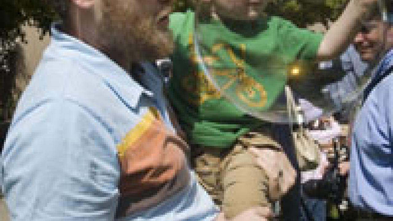 Cosumnes River College Professor James Frazee holds his 2-year-old son, Caleb, as they chase bubbles at the Multicultural Childrens Faire in the courtyard of Hart Hall.