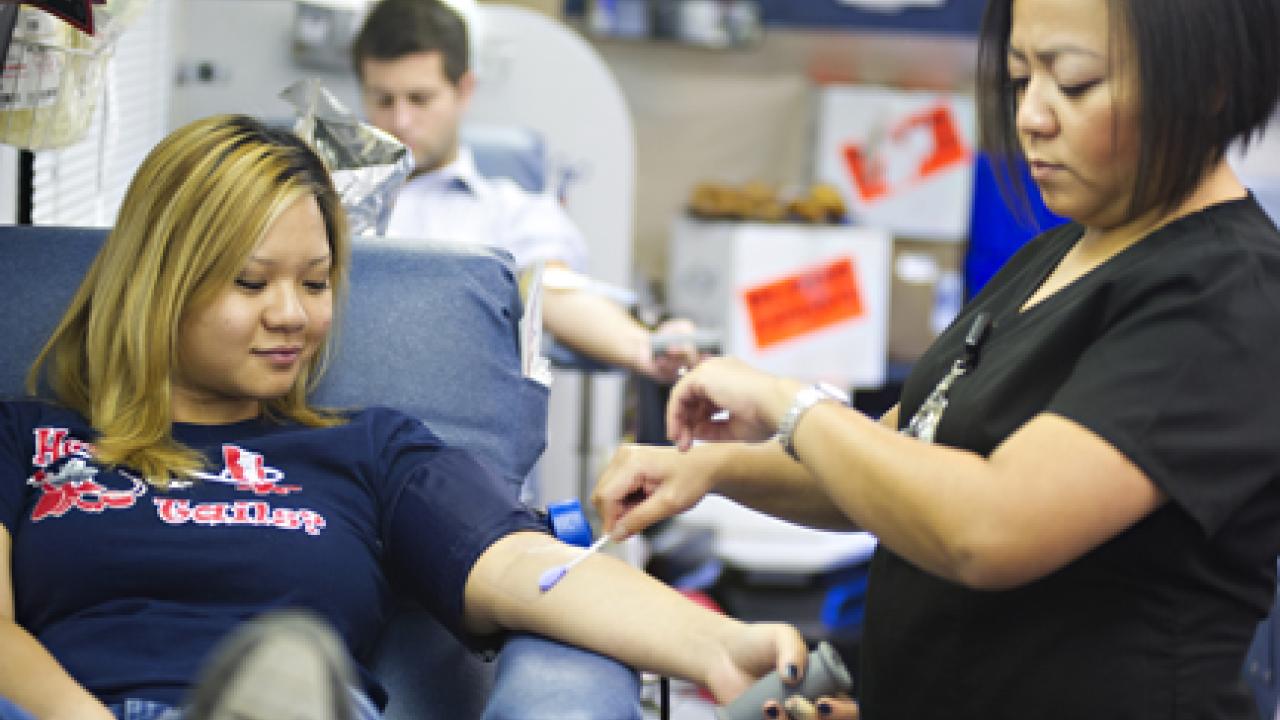 Photo: In the bloodmobile, Abby Lee, head charge nurse, prepares to draw blood from Jennifer Truong, a senior animal science major, on Aug. 28, 2012.
