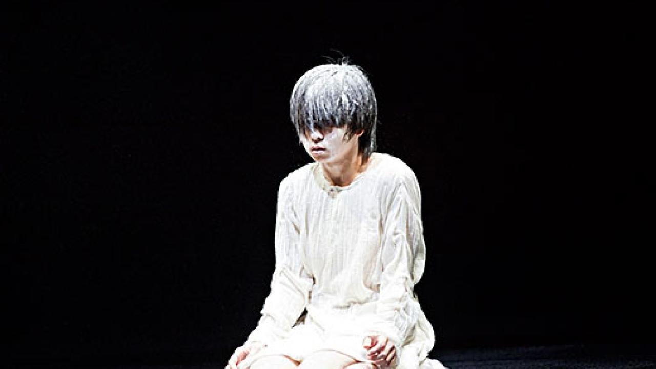 Person kneeling on floor, covered in white powder