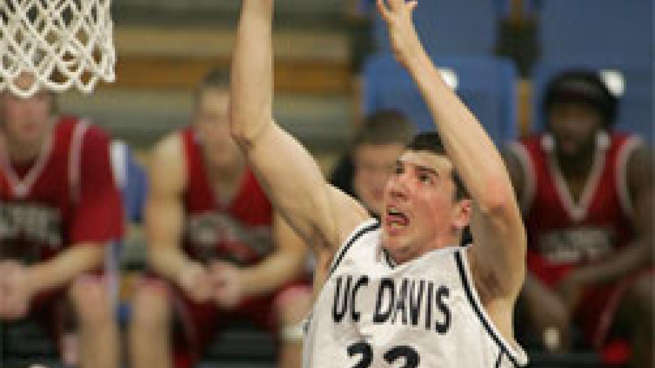 photo: man tossing ball at hoop