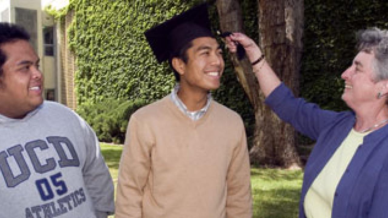 Maddy Rehrman, commencement coordinator for the College of Letters and Science, demonstrates proper tassel etiquette. Her model is Eric Zamora, and lo