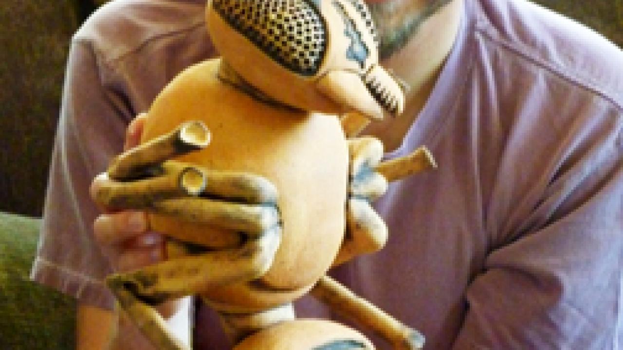 Radomir Schmidt holds a ceramic wasp, about 20 inches tall.