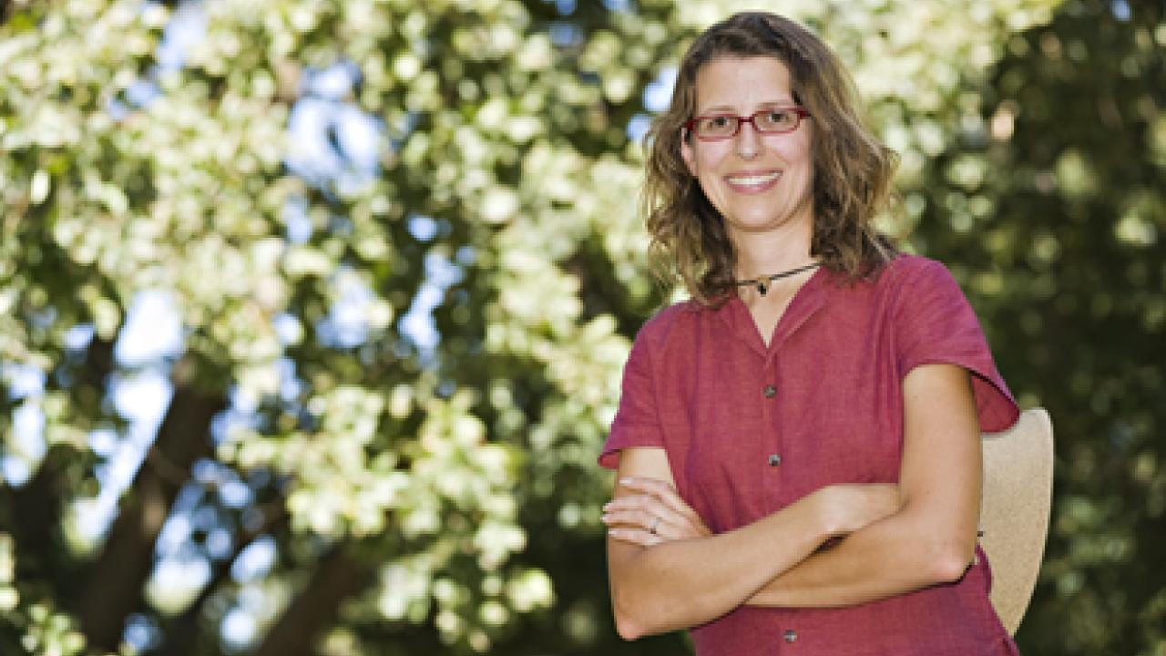 Emily Griswold stands amid the magnificent trees of the Shields Oak Grove.
