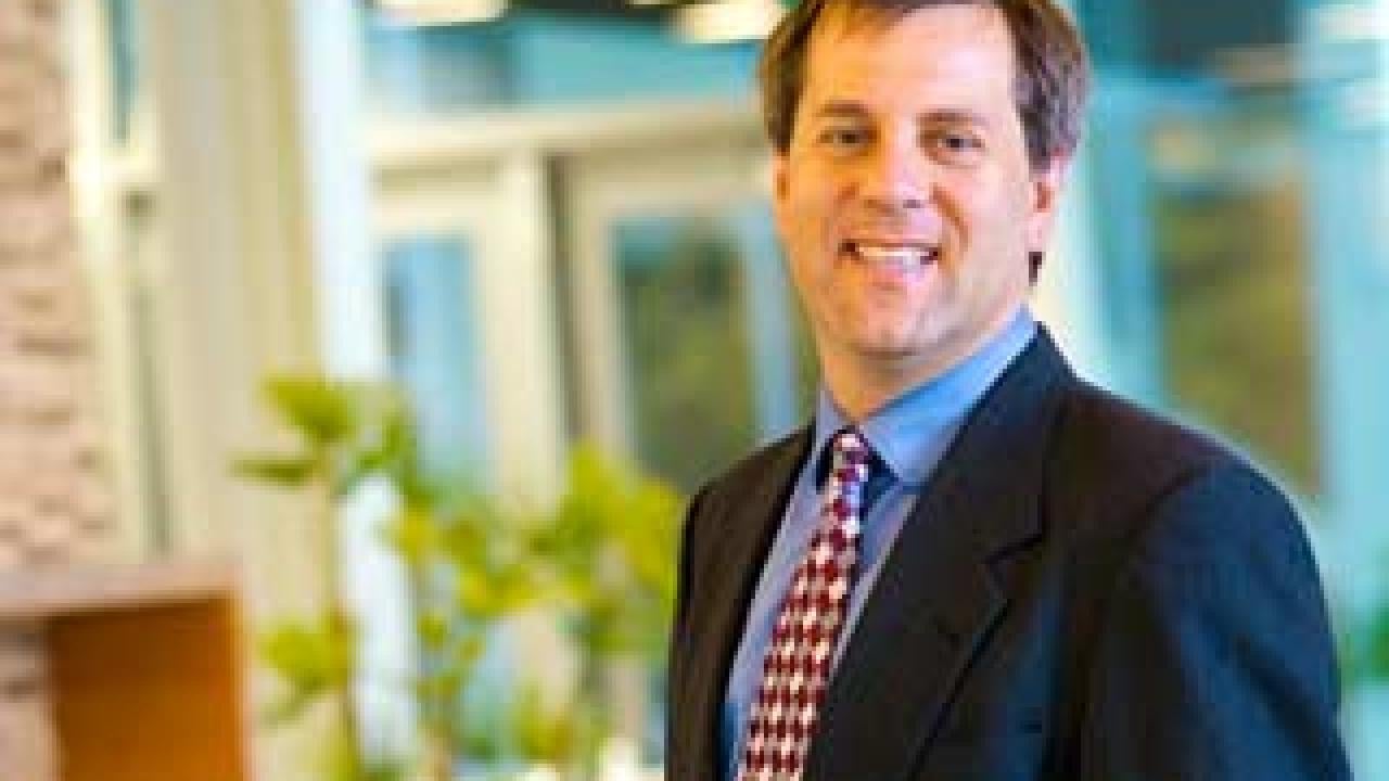 Man posing in a windowed foyer