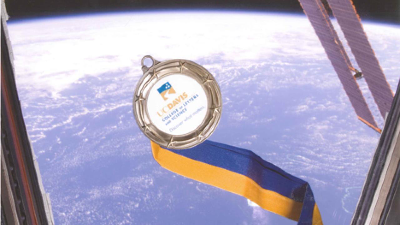 Photo: A College of Letters and Science commemorative medal is floating in space, inside the cupola observatory, on the International Space Station.